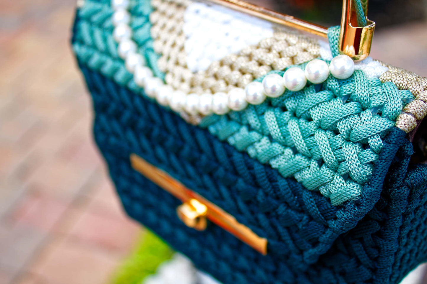 WholEmollient Atelier The I. Collection Emerald Tide — teal cord handbag with pearl trim and gold top handle, angled view